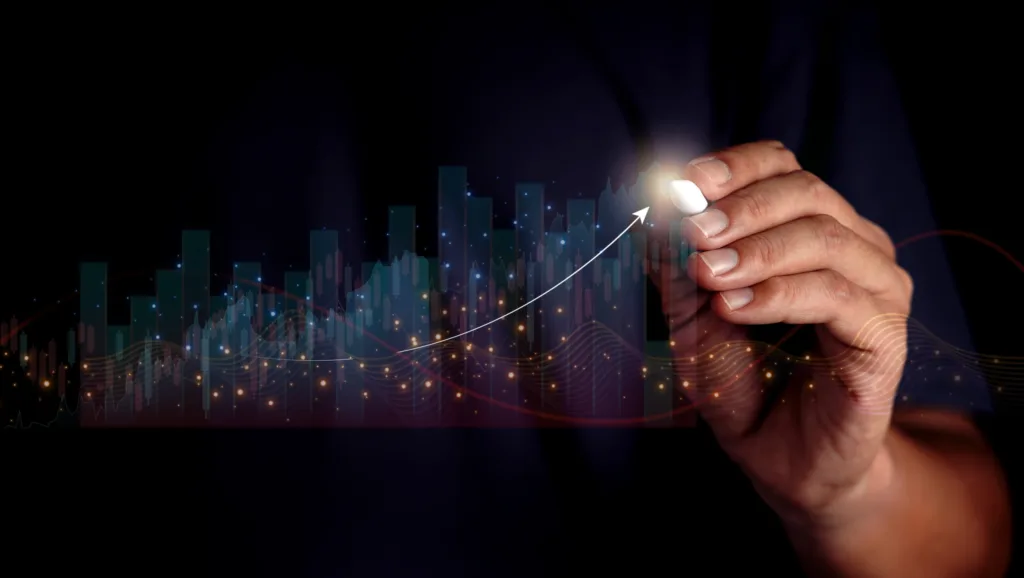 Hand drawing upward arrow on digital financial chart, symbolizing growth and success in business market analysis.